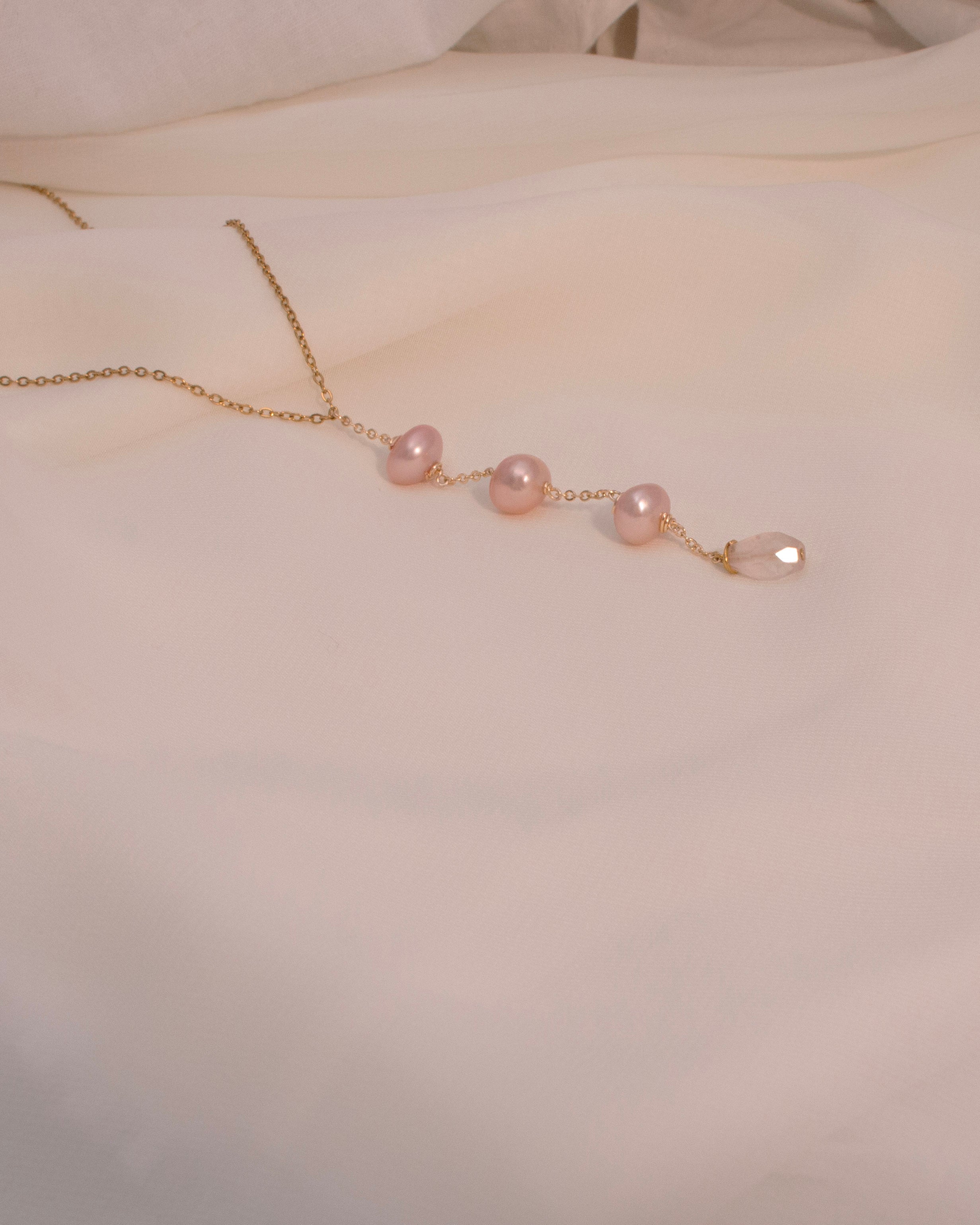 Necklace with pink pearls on a soft beige background