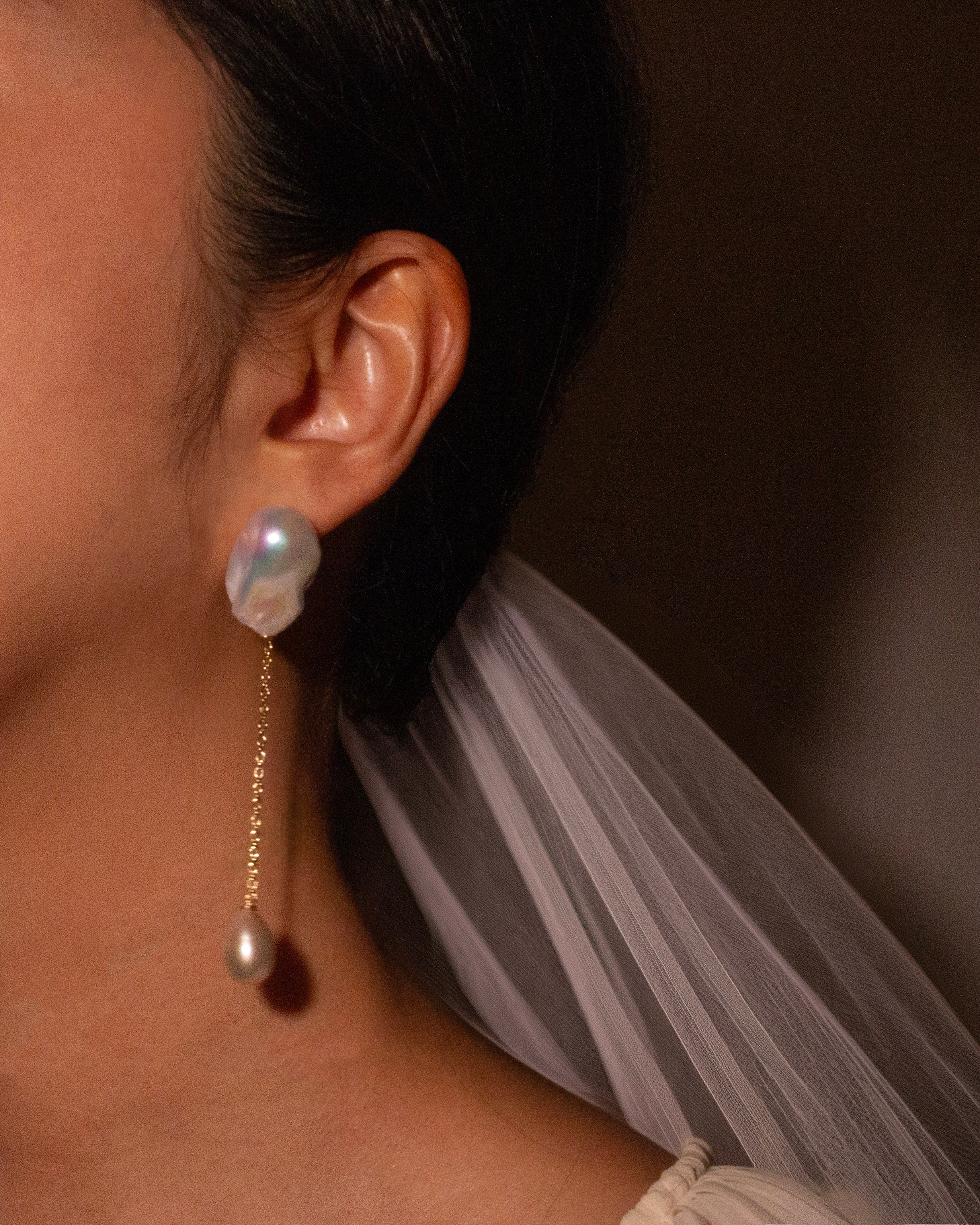 baroque Pearl earring worn by bridal with a neutral background