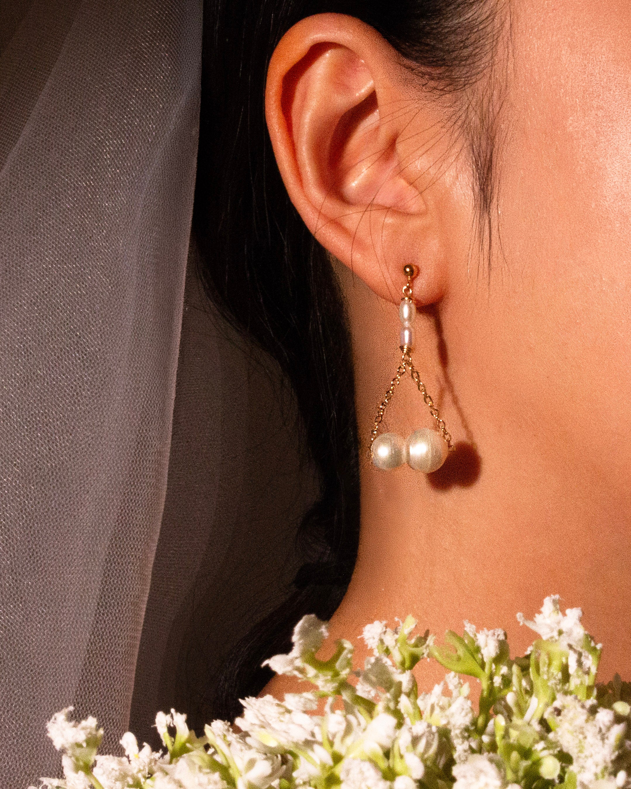 Pearl earring worn by a bridal with a blurred background