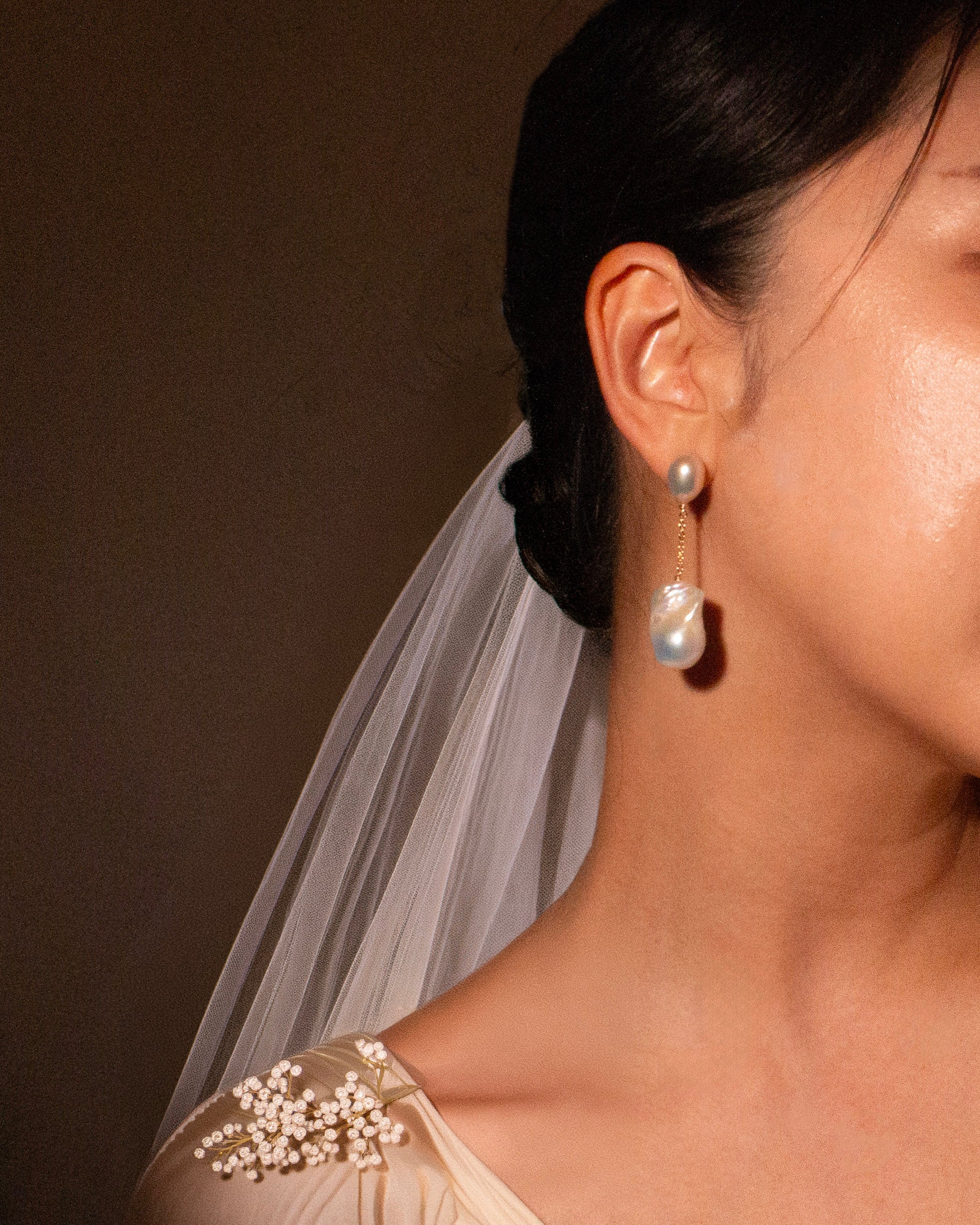 baroque Pearl earring worn by a person with a blurred background