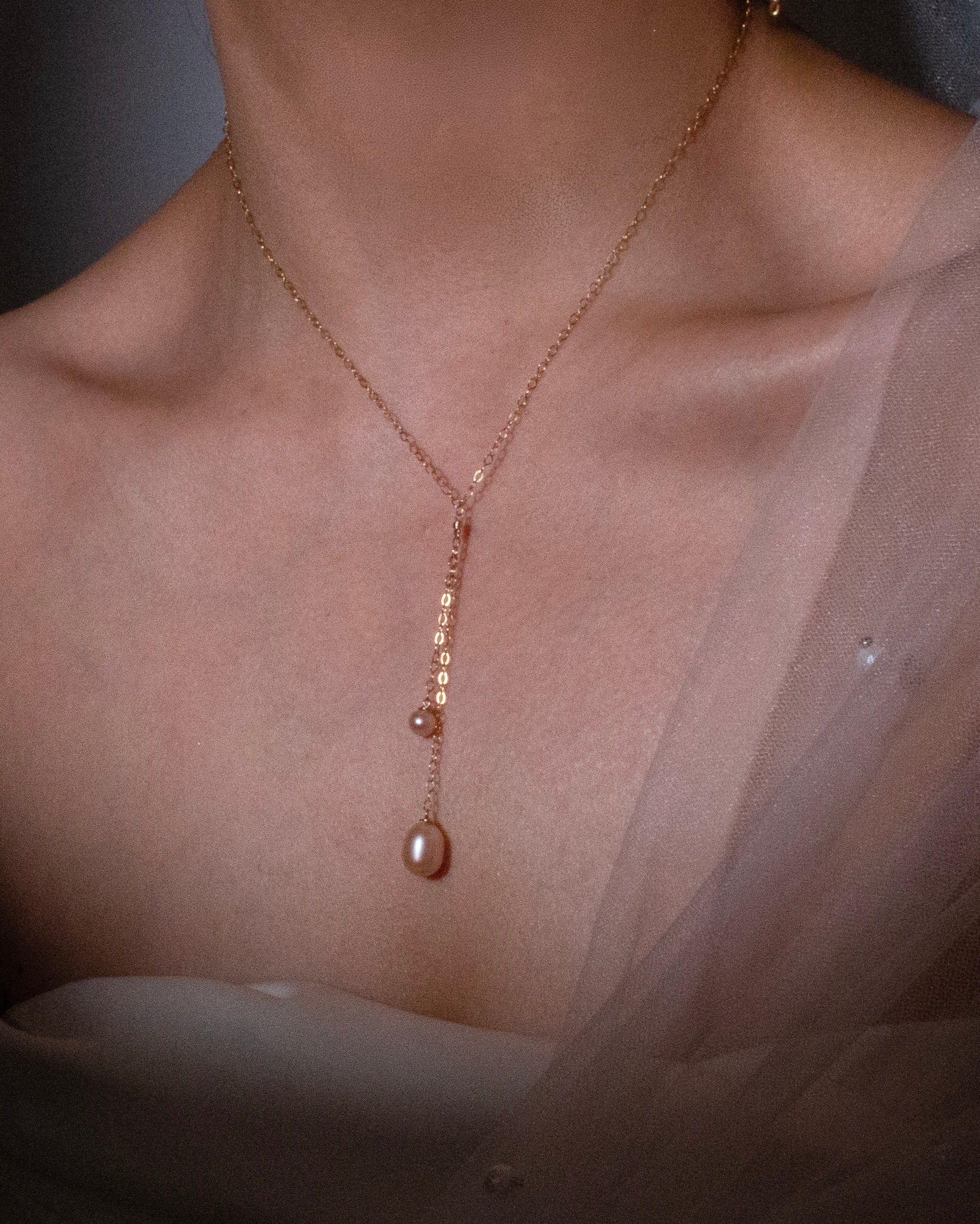 gold necklace with a Pearl on a blurred background