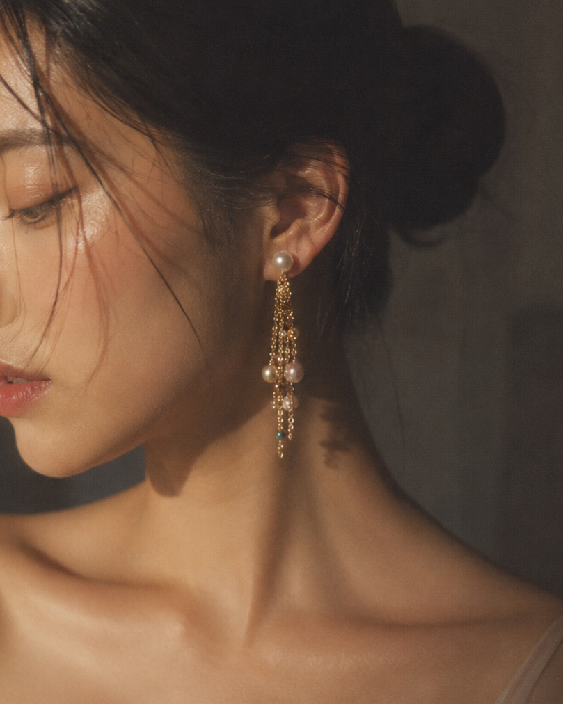 Close-up of a woman wearing elegant earrings with a neutral background