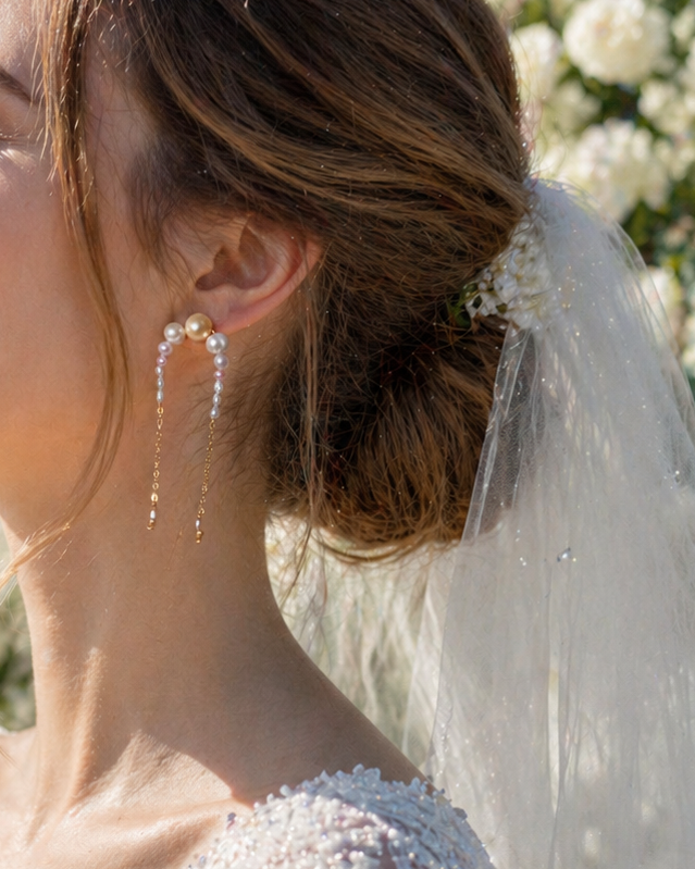 Bride in a white wedding dress with a veil, surrounded by white flowers.